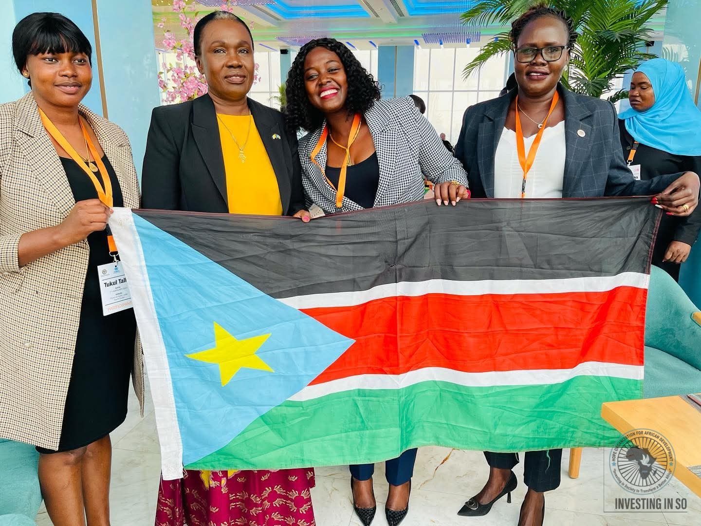 HOFAD representatives holding the South Sudan national flag at a regional conference